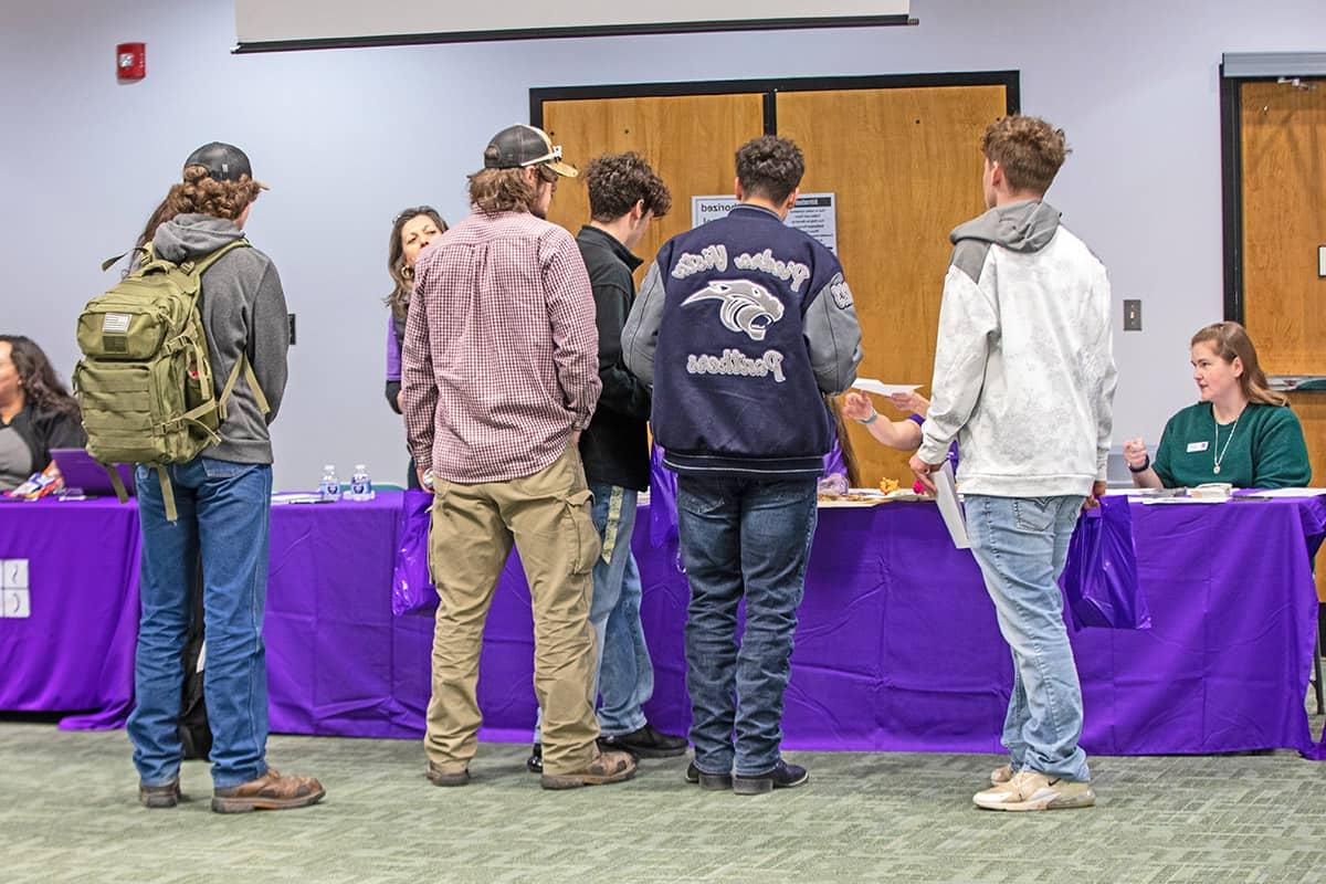 High school students get some information from one of the info tables at orientation.