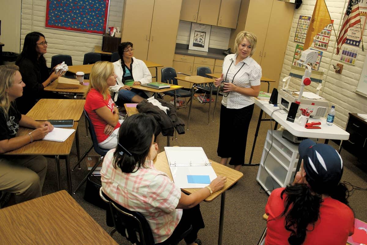 Pictured is an Instructor who got their degree in Teacher Education is instructing two students.